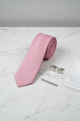 Textured pink silk tie displayed with silver cufflinks and a pocket square.